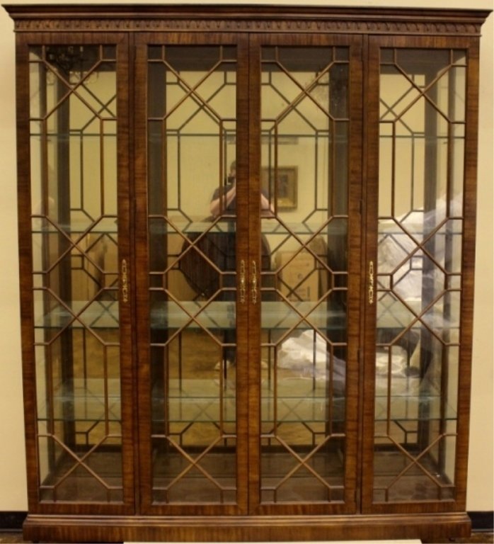 Henredon Walnut Four Door Display China Cabinet: 20th century Henredon walnut four door display china cabinet with projecting pediment over a carved cornice and four glazed doors enclosing the illuminated interior fitted with four thick glass shelve