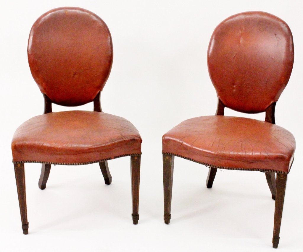 Pair of 19th-C. Leather Occasional Side Chairs: Pair of matching 19th century George IV leather occasional chairs with oval backrest and brass nail-head trim. Empire-style front carved legs, and curved back legs. Square tapered front legs terminati