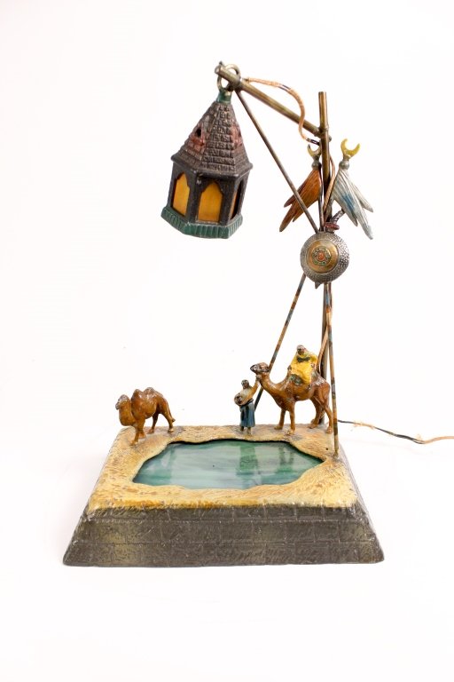 Austrian Cold Painted Bronze Figural Lamp: Austrian, 20th Century. Cold painted bronze figural lamp fashioned as a lantern with light brown panels hanging above a middle eastern man seated on a camel alongside a standing woman and a camel, bor