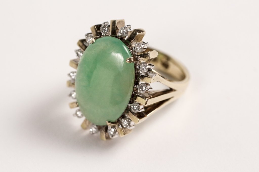 14k Gold, Jade & Diamond Ring: Ladies 14k yellow gold ring with one 19 x 13.5mm oval green jade at center surrounded by an open spoke form with fourteen round brilliant cut diamonds weighing approximately 0.03ct each for 0.50 appro