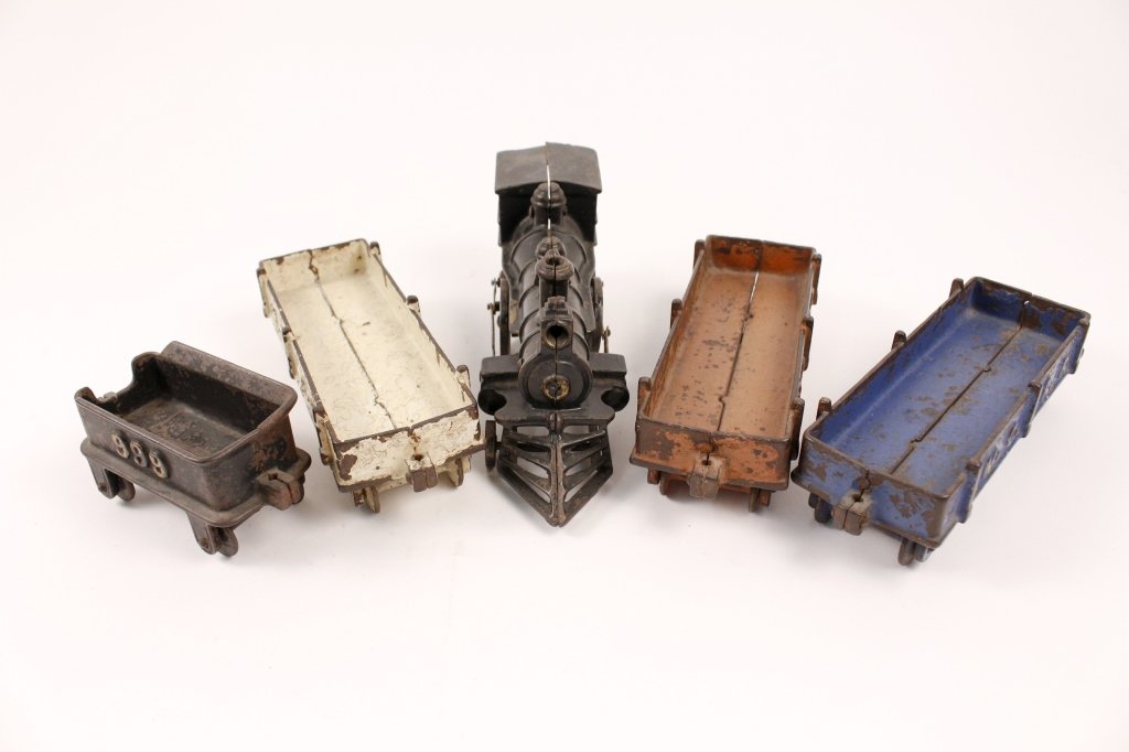5 Piece Cast Iron Train Set: Early 20th century. American style engine with cow catcher in front, No.999 embossed tender and three M.C.R.R. Freight or gondola cars. Engine height 3.25", width 10.25", tender height 2.5", width 5.2