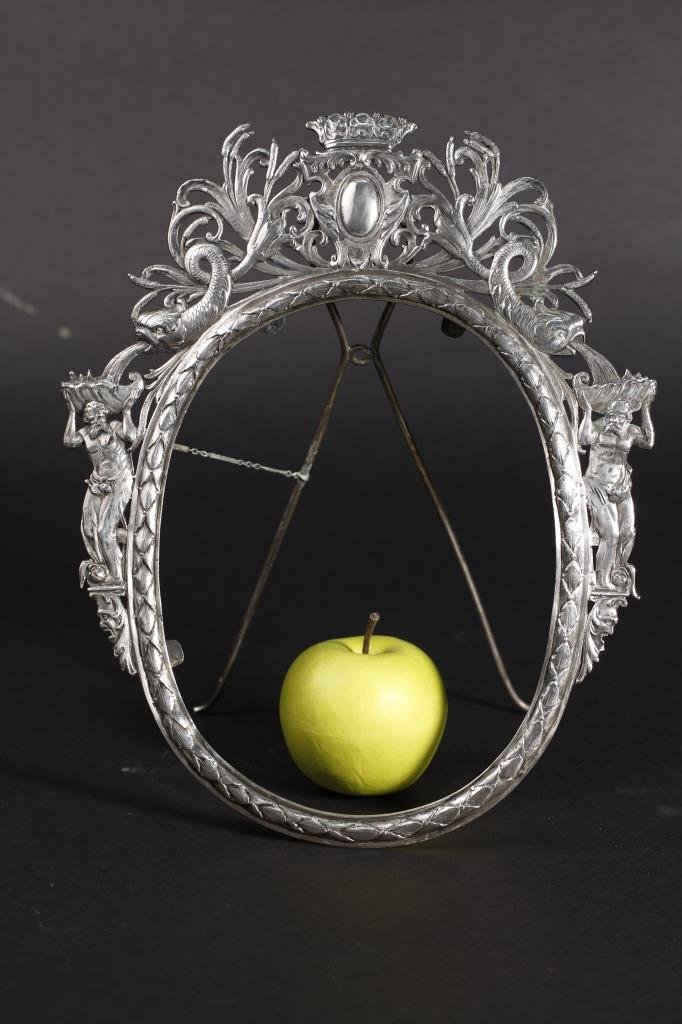 Continental Sterling Figural & Dolphin Motif Frame: Continental School, probably French, 19th Century. Sterling figural and dolphin oval picture frame surmounted with cabochon and crown flanked by pierced scrolling foliage trailing to dolphins spouting
