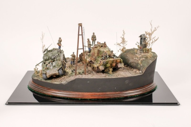 Finely Handled Mid 20th C. Military Diorama: American, mid 20th century (circa 1945), figural military diorama depicting a German King Tiger Tank stopped adjacent to a damaged US M4 Sherman tank with dead soldiers scattered among landscape and w