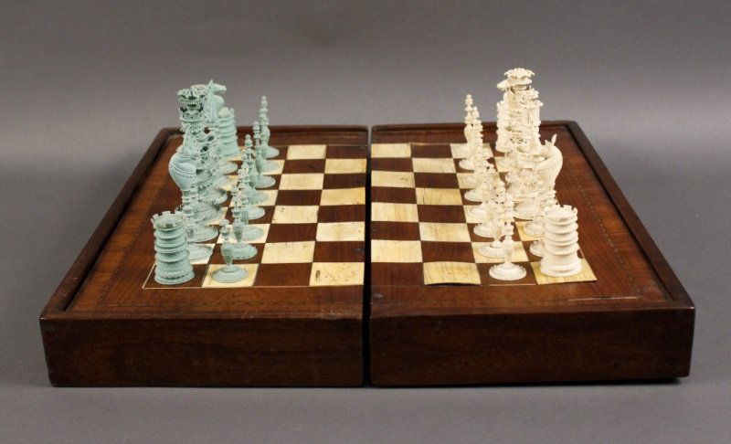 Carved Ivory Chess Set & Inlaid Game Board: Continental, Late 19th/Early 20th century. Finely carved and polychromed ivory chess set (fully complete) with ornate game playing pieces (one player with likely later light green painted finish), unm