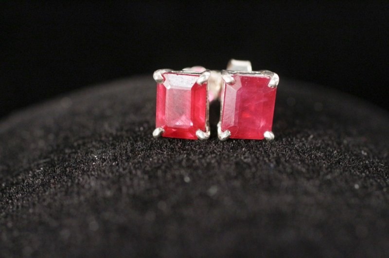 Pair of Ruby & Sterling Silver Earrings: Pair of ladies emerald cut natural ruby and sterling silver earrings. Earrings with pin backs. Apparently unmarked. Earrings measure approximately 6.3mm x 7.6mm. Total weight approximately 3.6 grams. 