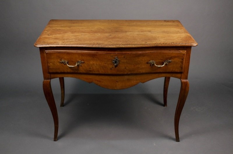 French Provincial Fruitwood Table, 18th C.: French, 18th century. Provincial fruitwood serpentine table with one long pull out drawer at top with bronze metal hardware pulls flanking escutcheon above shaped apron raised on four cabriole legs. H