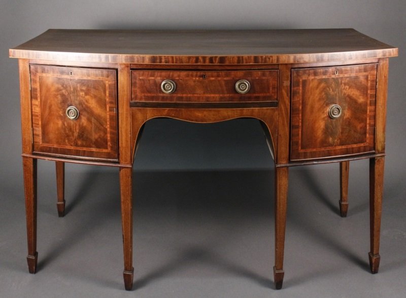 English 19th C. Mahogany Hepplewhite Sideboard: English, mid 19th century (circa 1840). Mahogany wood Hepplewhite sideboard with bow front accented with banded accents throughout with center pull out drawer with compartments within flanked by hinge