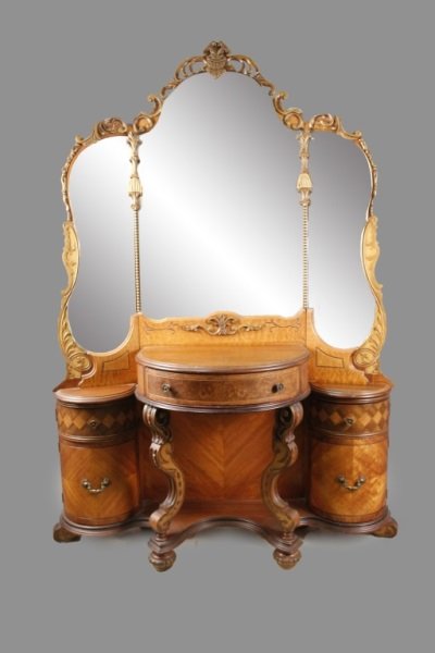 American Victorian Walnut Ladies Vanity: American, Early 20th Century. Victorian walnut ladies vanity or dressing table, the three mirror back within a pierced foliate scrolling frame over a bowfront top with frieze drawer on foliate scrolle