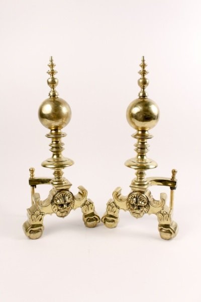 Pair of Late 19th Century French Brass Andirons: French, Late 19th century. Pair of brass andirons with turned finial above round ball or orb on turned shaft above lion's head flanked by scrolled legs with leaf decoration and primitive ball and claw