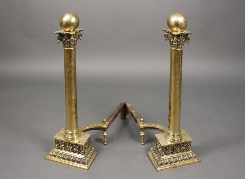 Pair of American Classical Style Brass Andirons: American, Early 20th Century. Pair of American Classical style andirons modeled as a leafy Corinthian capitals surmounted with large spheres on rectangular stepped base with anthemion and egg and dart