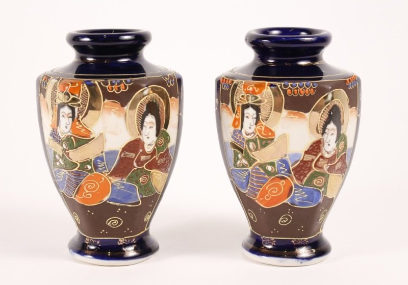 Pair of Japanese Noritake Satsuma Style Vases: Japan, Early 20th Century. Pair of Noritake Chikaramachi Satsuma style porcelain vases on cobalt ground with continuous samurai decoration and gold & moriage detailing. Height 6.15", width 3".