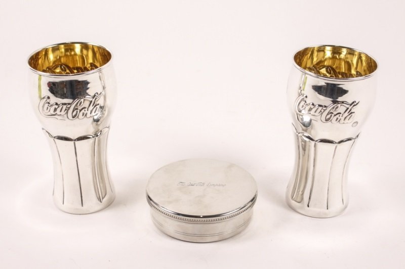 Three Coca Cola Items, Sterling & Tiffany & Co.: Collection of three Coca Cola themed items comprising of a pair of Turkish Cendereci 925 sterling silver soda shop glasses with Coca Cola advertising logo on exterior with gold washed interior, marked