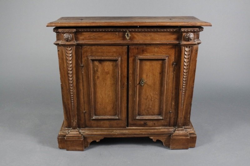 17th Century Italian Baroque Style Small Credenza: Italian, Circa 1670. Italian Baroque style two door small credenza or side cabinet with snipe hinged molded top concealing open compartment over a pair of paneled cupboard doors flanked by carved imbr
