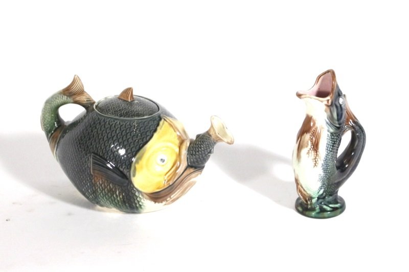 Two Majolica Fish Motif Items, Glug & Teapot: Early 20th century. A group of two Majolica items comprising of a glug jug depicting a naturalistic fish with curled tail and wide open mouth turned upward acting as vase opening (approximately 7" tal