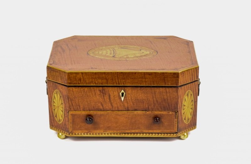 Inlaid Satinwood Sewing Box with Shell Motif: English, 19th century. A satinwood hinged lid sewing or jewelry box with inlaid detail on lid of a shell within an oval cartouche surrounded by bands of ebony stringing, chamfered corners decorated wi
