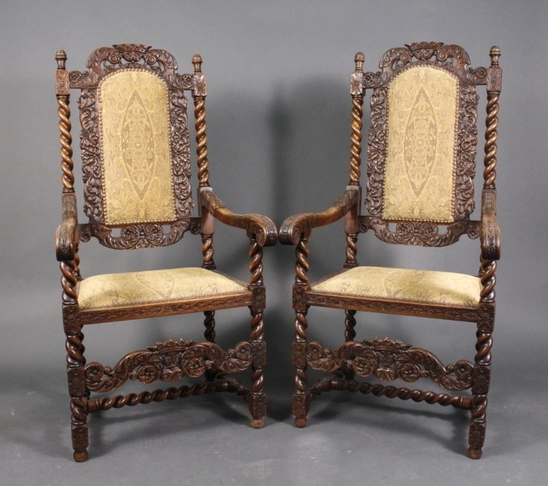 Pair of Carolean Style Oak Throne or Elbow Chairs: English, 19th Century. Matched pair of Carolean style oak throne or elbow chairs, the center of the crest with crown shaped flowerheads flanked by scrolled acanthus, over an upholstered back within pi
