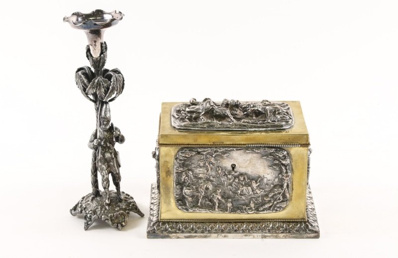 Brass Tea Caddy w/ Relief & Figural Candlestick: Group of two figural metal items comprising of a brass and white metal sarcophagus form tea caddy with leaf tip decorated pedestal form base and each side of caddy decorated with a repousse panel in h
