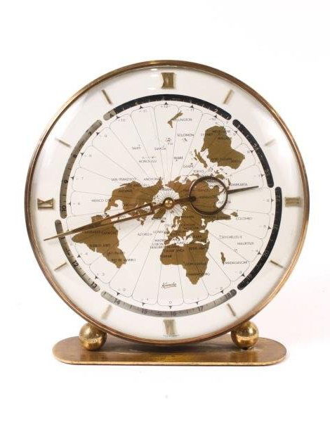West German Kundo Desktop World Clock, c. 1960s: Kieninger & Obergfell Company (German, 1912- ). A brass mounted table or desk world clock with large ivory tone circular face and brass minute and hour hands, set upon a brass plinth mounted with two