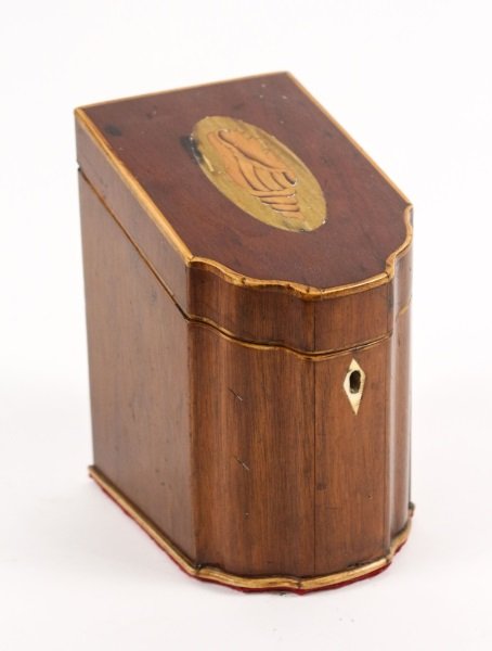 Diminutive Tea Caddy in Form of Knife Box: English, 19th century. Sheraton mahogany and satinwood tea caddy in the form of a diminutive serpentine knife box with slanted hinged top inlaid with conch shell in oval medallion. Ivory escutcheon on