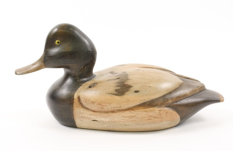 Tom Taber Stained Wood Decoy Duck w/ Yellow Eyes: American, 20th century. Tom Taber carved and polychrome wood duck decoy with brown body, lighter brown accents at cener, yellow glass eyes and light tan bill. Marked on bottom "Tom Taber". Approximate