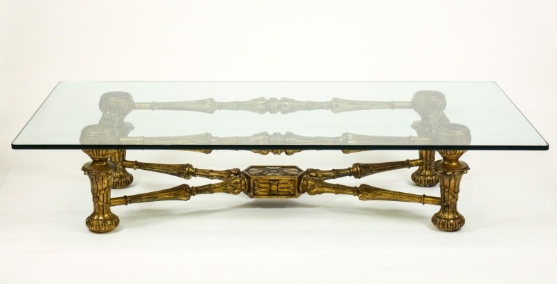 Continental Giltwood Carved Glass Top Coffee Table: Continental, 20th century. Large giltwood and red bole carved French style coffee, cocktail or low table with thick glass top on 4 rosette carved and ribbon wrapped acanthus supports united on the top
