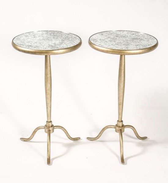 Pair of Gold Toned Iron Mirrored Top Side Tables: 20th century. Pair of two light gold toned heavy iron framed accent or side tables with round inset mirrored tops with antiqued finish above a slightly swelled shaft terminating on a tripod base. Unma