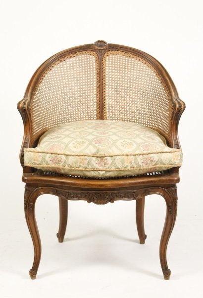 French Louis XV Style Caned Bergere Chair: French, late 19th century. French Louis XV style caned bergere or armchair with shell cresting over caned back to scrolled and foliate carved arms over a serpentine seat with removable seat cushion an
