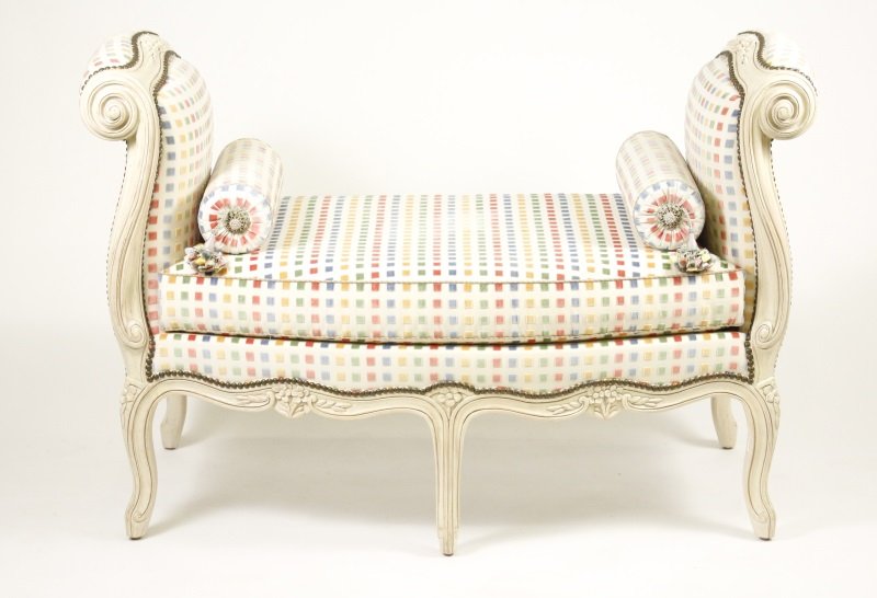 Louis XV Style Upholstered Window Bench: Contemporary Louis XV style cream painted window bench with high scrolled arms with floral motif, overall raised on thick cabriole legs with floral knees, shaped apron. Seat and arms upholstered in mu