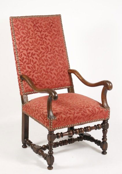 French Louis XIII Walnut Carved Fauteuil: French, 19th century. French Louis XIII style walnut carved fauteuil having a leaning rectangular upholstered back with curved arms and supports above an upholstered seat raised on block and turned le
