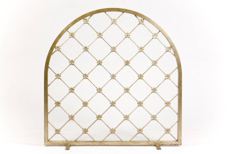 French Style Glass Latticework Fire Screen: French style metallic painted fire screen with arched frame and conforming glass plate to the back. The front decorated with floral latticework, each petal mounted to the center with clear faceted sti