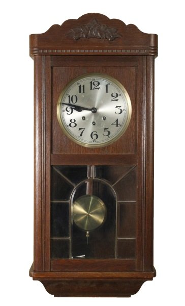 Kienzle 8 Day Wall Clock w/ Westminster Chimes: German, early 20th century. Kienzle stained oak 8 day wall clock with Westminster chimes, the scalloped shaped pediment over the frieze centered with floral molding and an egg and dart cornice, the pa