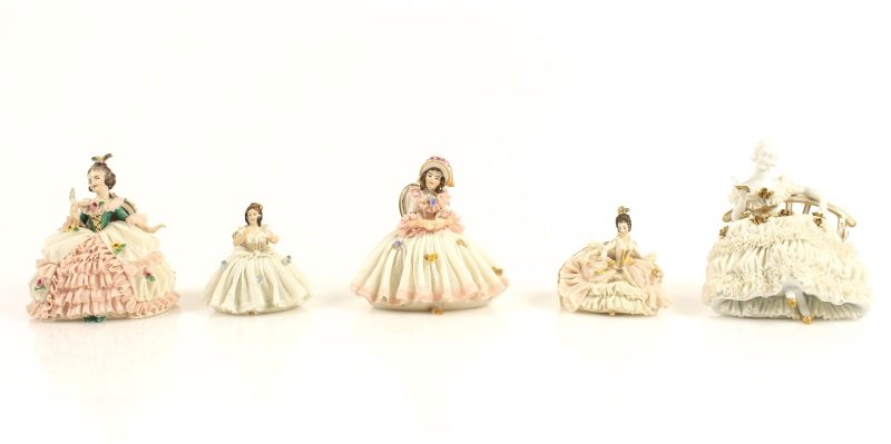 Five Dresden Lace Porcelains, Seated Ladies: German, 20th century. A collection of five Dresden lace figurines depicting seated ladies, one with a lady in green bodiced gown with white and pink lace skirt and holding a fan in her right hand, mar