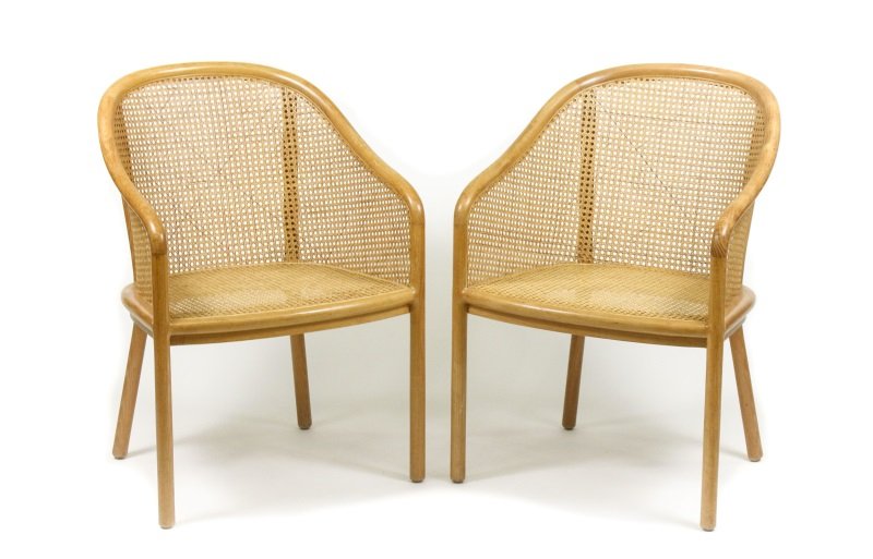 Pair of Ward Bennett Caned Armchairs: American, circa 1970s. Pair of caned Ward Bennett armchairs in oak, the tub formed back with continuous frame enclosing caned back, sides and seat on turned legs. Each chair with applied red manufactu