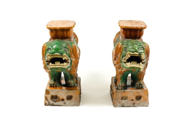 Pair of Chinese Sancai Glazed Foo Dog Stools: Chinese, early 20th century. Matched pair of Chinese sancai glazed figural stools or side tables, each modeled as a caparisoned foo dog or Buddhist lion, standing foresquare with snarling mouth open, 