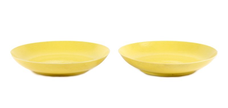 Pair of Chinese Imperial Yellow Dishes, Guangxu: Chinese, Guangxu period (1875-1908). Matched pair of Chinese Imperial-yellow monochrome glazed porcelain dishes; of circular and shallow form. The tag to the underside retailed by Leo Gould, 699 Madis