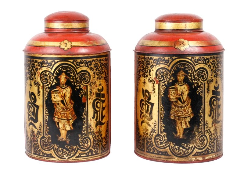 Pair of Red Chinoiserie Lidded Tea Canisters: English, Mid 19th century. Pair of Chinoiserie tole decorated tin tea canisters, each having a red body with gilt accents centered by a scenic reserve depicting Orientalist carrying tea on black groun