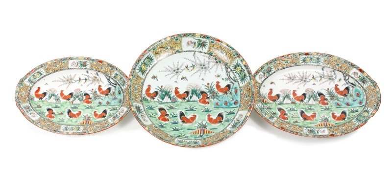 Set of 3 Chinese Porcelain Rooster Motif Serveware: Chinese, 20th century. A set of two porcelain platters and one large shallow bowl, the platters of almond form and the bowl being round, each decorated to basin with seven red roosters in a landscape