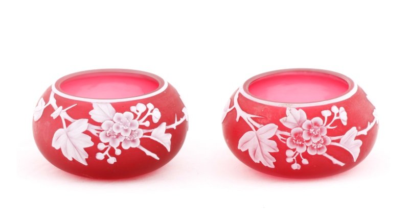 Pair of English Cranberry Cameo Glass Bowls: Attributed to Thomas Webb & Sons (English, 1837-1990), circa 1890. Pair of cranberry cameo glass bowls both small bowls in cranberry satin with cameo carved white floral decoration. Neither bowl appar