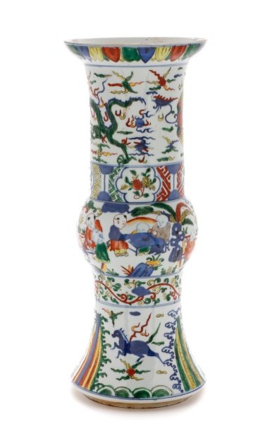Ming Dynasty Style Wucai Decorated Porcelain Gu: Chinese, late 19th/ early 20th century. A Ming Dynasty style porcelain Gu form beaker vase with wucai enamel decoration, the flaring round foot with a band of stylized waves surmounted by galloping ho