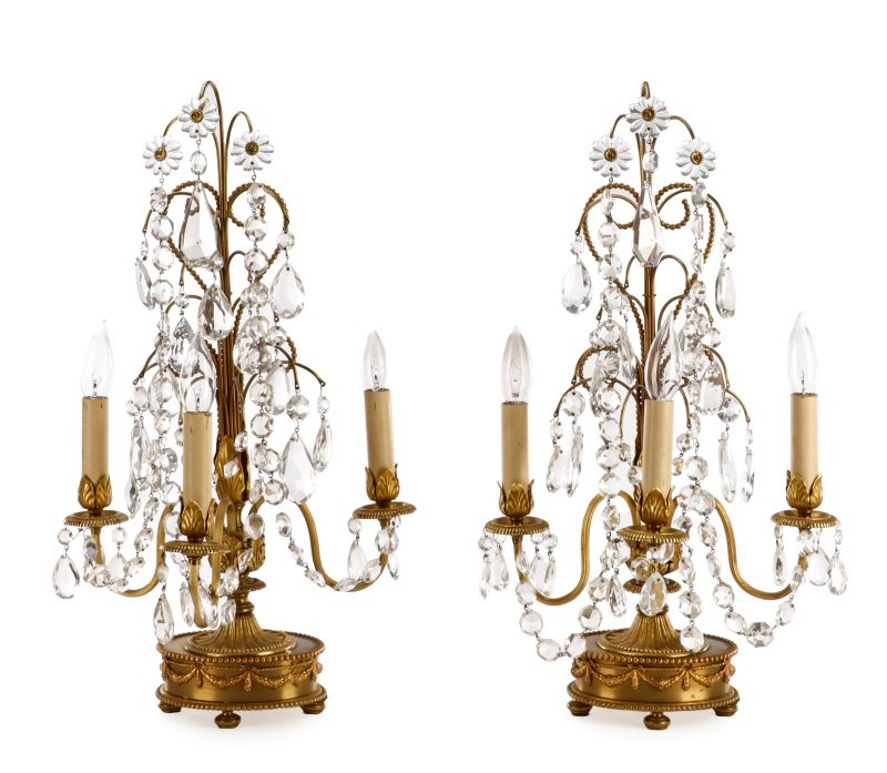 Pair of French Crystal Three Light Girandoles: French, 20th century. A matched pair of Louis XVI style gilt metal and crystal three light girandoles or mantle lusters, each having scroll branches emanating from a pole standard headed with crystal