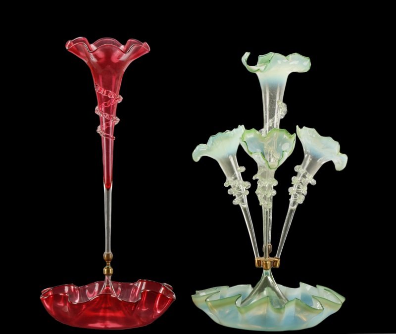 Two Victorian Glass Epergnes: Green & Cranberry: American, late 19th/ early 20th century. A group of two Victorian blown glass epergnes comprising one four stem epergne in green opalescent glass with a ruffled lower bowl with conical center issuing