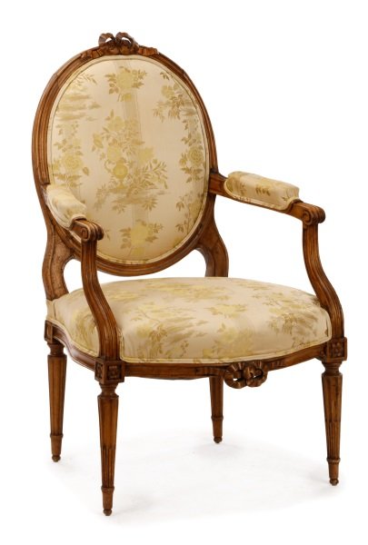 Louis XVI Period Carved Fauteuil la Reine: French, fourth quarter 18th century. Louis XVI beech wood carved fauteuil la reine having a oval padded back surmounted with pierced carved ribbon cresting, the scrolled arms with padded rests enclosi
