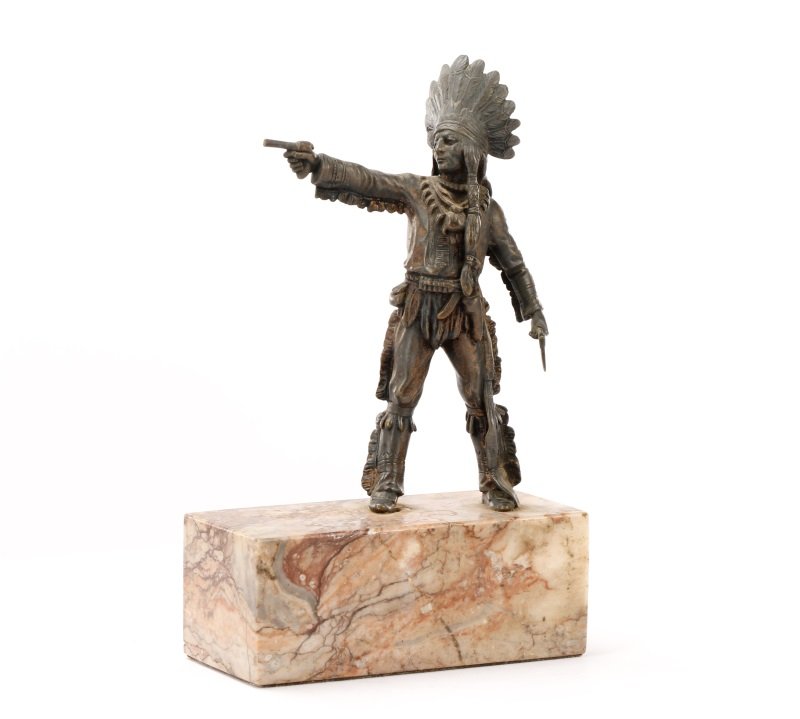 Carl Kauba Style Native American Warrior Bronze: Manner of Carl Kauba (1865-1922), circa 20th century. Patinated bronze figural sculpture depicting a standing male Native American Indian warrior with feathered headdress and long braids wearing a lon