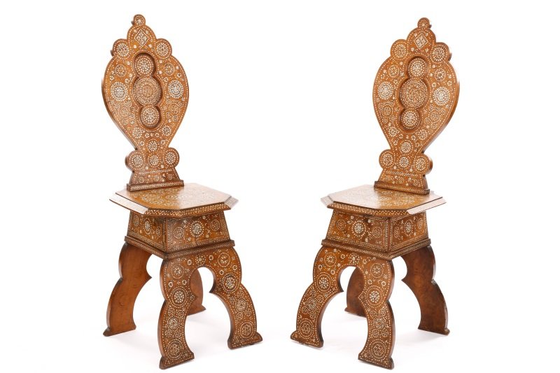 Pair of Moorish Style Inlaid Walnut Hall Chairs: Northern Italy, late 19th Century. A matched pair of Moorish style bone inlaid walnut chairs each having a quatrefoil shaped paneled back above a hexagonal shaped seat raised on scroll carved shaped l