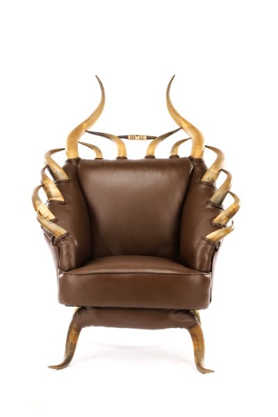 Western Longhorn Upholstered Club Chair: American, 20th century. A longhorn steer club or lounge chair in the manner of William Mittmann or Wenzel Friedrich, upholstered in chocolate or tobacco leather, the arms and back mounted with 14 grad