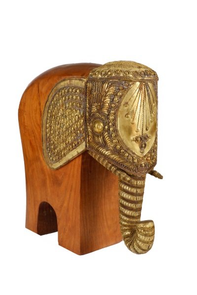 Mid Century Modern Elephant Wood Sculpture, Raymor: Raymor Import Co (America, 1941-1980), circa 1960. A walnut carved and brass mounted sculptural figure depicting an Indian elephant, the head,ears and trunk dressed in an elaborate hand-hammered brass