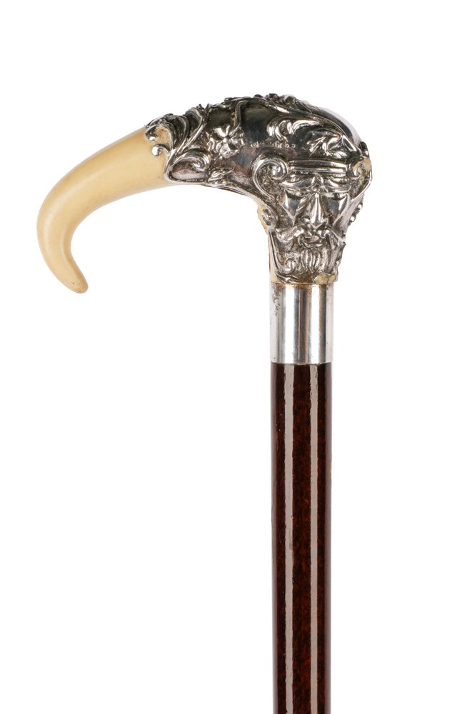 Italian Sterling Silver & Wood Walking Stick: A 20th century Italian sterling silver and wood walking stick or cane, the silver handle decorated to one side with a female mask, the other a male mask amidst scrolling foliage and centered by a vaca