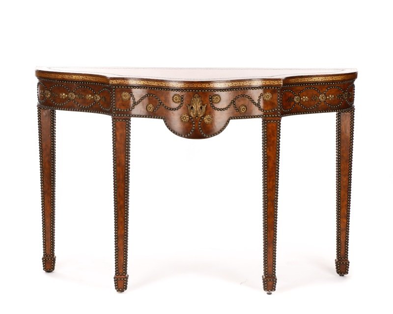 Maitland Smith Brown Leather Studded Console Table: Maitland Smith (American, 1979-), late 20th century. A leather wrapped console table, having a shaped serpentine top with a gilt tooled border and edge, over a conforming apron, decorated with swagged