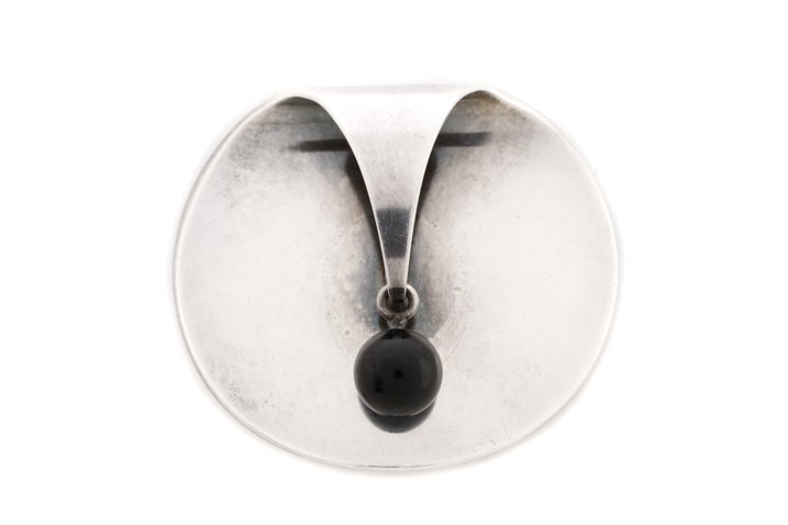 Nanna Ditzel for Jensen Sterling & Onyx Brooch: Nanna Ditzel (Danish, 1923-2005) for Georg Jensen (Danish, founded 1904). A sterling silver and onyx 336 brooch, having a circular form with a curled upper edge and a suspended onyx pendant. Stamped S