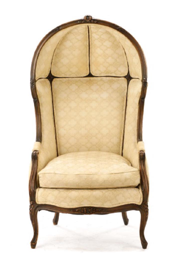 French Louis XV Style Domed Porter's Chair: French, late 19th century. A Louis XV style porter's chair, having an upholstered dome, crested with a carved flower bouquet, the frame carved with acanthine foliage and rosettes, with fauteuil arms, 